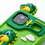 Detalle del celular juguete H1: cubierta verde, cámara y parlante con diseño dinosaurio